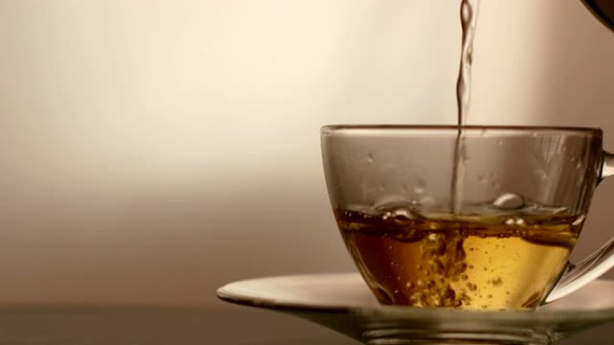 多莉·肖尔，倒茶。将茶倒入玻璃透明茶杯中。喝茶时间。透明玻璃茶壶和茶杯。