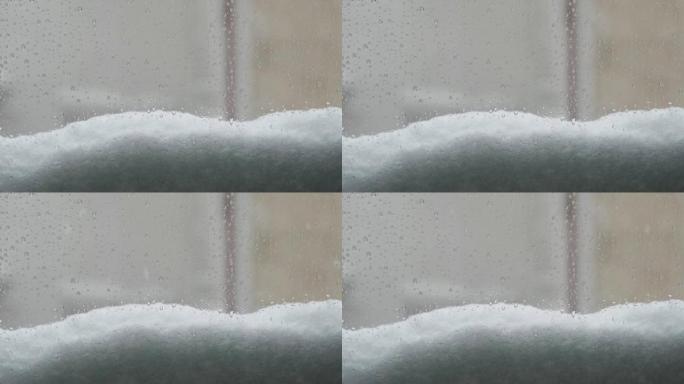 一扇有水滴和落雪的窗户的景色