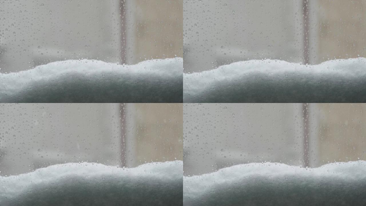 一扇有水滴和落雪的窗户的景色