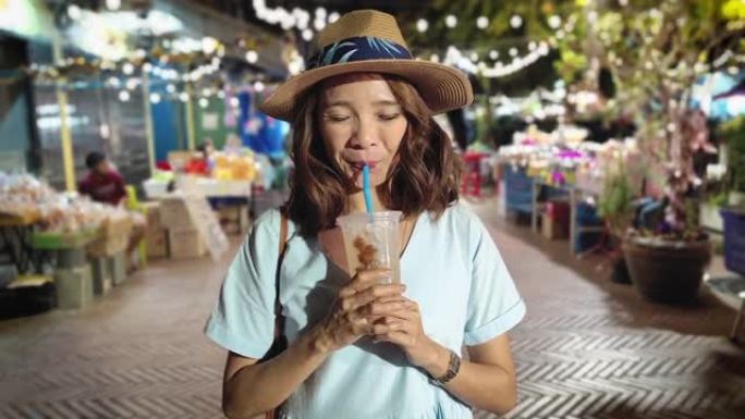 一名妇女在泰国街头美食中喝果汁