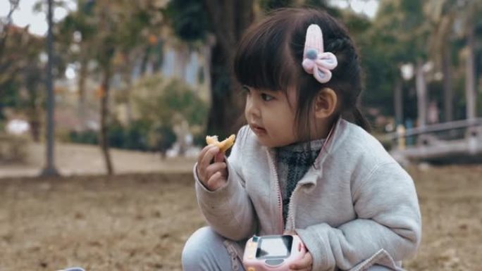 可爱的中国女孩在公园吃早餐和野餐