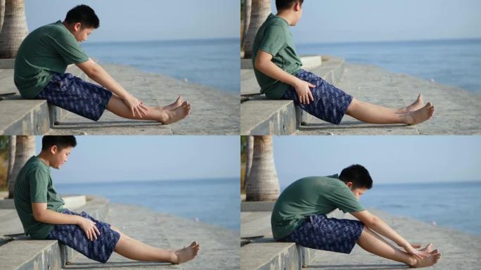 亚洲男孩早上在海滩上锻炼，有晴天，生活方式的概念。