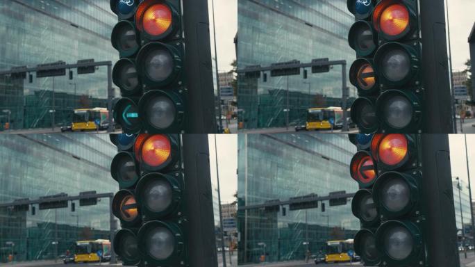 慢动作德国首都柏林市中心十字路口的典型红绿灯。绿色箭头打开。切换到黄色和红色。背景是无法识别的骑自行