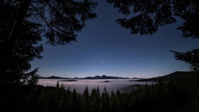 蓝色夜空，群山中有星星森林，雾云在傍晚自然景观时间流逝中快速运动