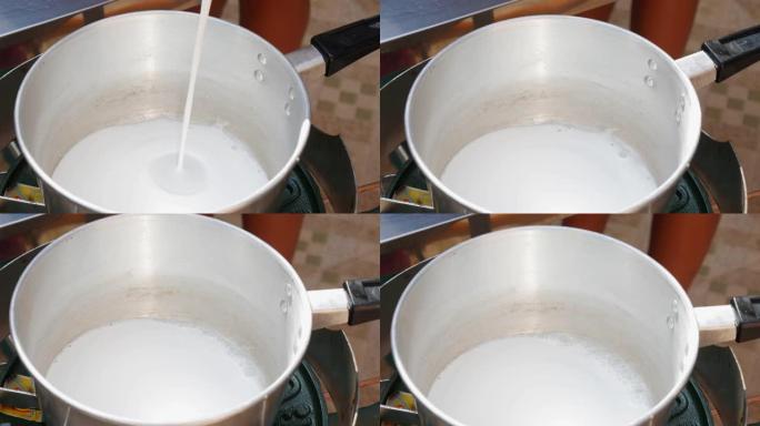 将椰奶倒入锅中。一步一步煮汤姆山药汤。泰国菜。特写。4k
