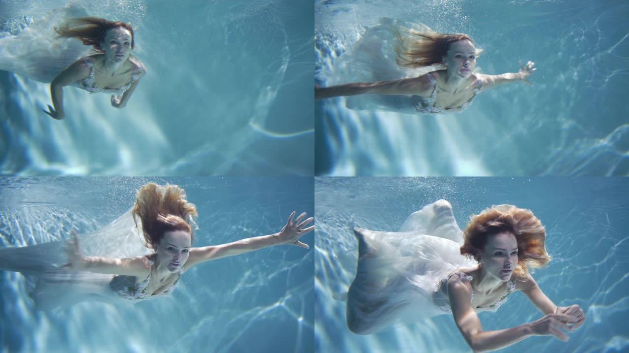 年轻的金发女人穿着复古白色连衣裙在水下游泳
