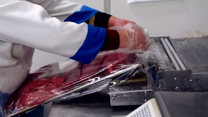 肉类销售商的特写镜头将新鲜的肉放在肉店的托盘上。