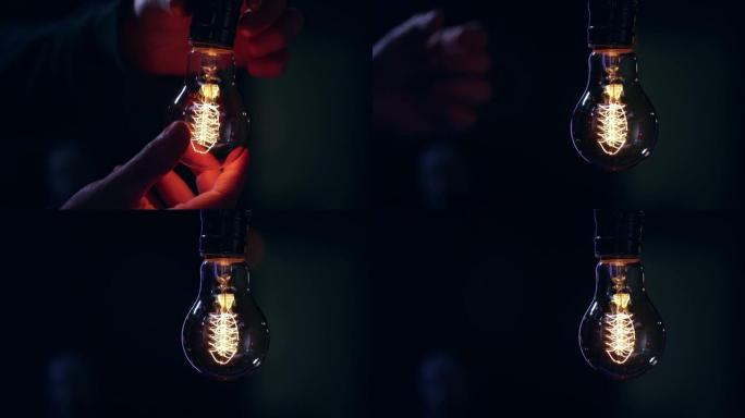 一个人在装饰灯泡中扭曲，它在黑暗的复制空间中亮起。
