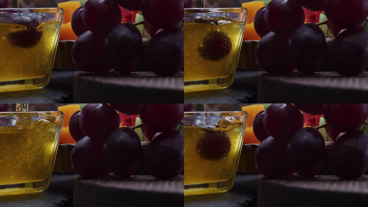 奶酪和面包配蜂蜜和水果。将葡萄浸入蜂蜜中。特写前视图