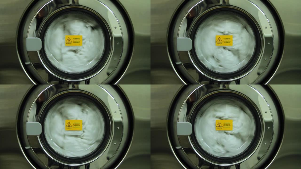 洗衣机转动特写。景。工业洗衣机工作。工业洗衣机洗衣的特写