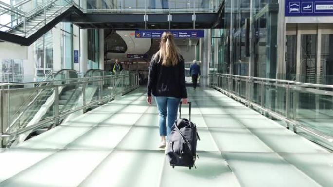 一个女人在机场散步的慢动作视频。