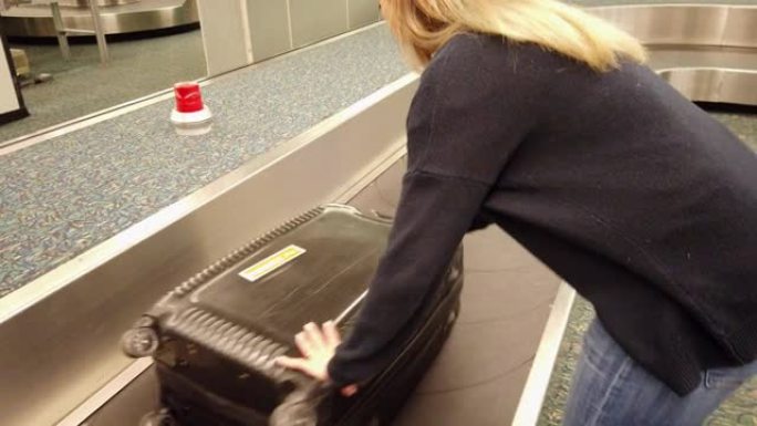 一个女人到达后拿回行李的视频。