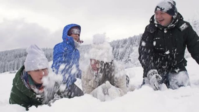 一群朋友兴高采烈地互相撒雪。美好的冬日。在白雪皑皑的森林背景下