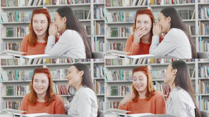 女大学生朋友在图书馆窃窃私语笑语