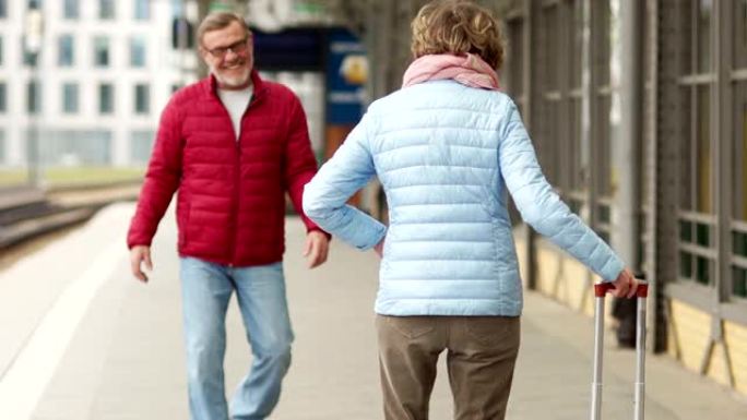 丈夫和妻子在春天漫步穿过城市。看框架，拥抱和大笑。约会成熟夫妇