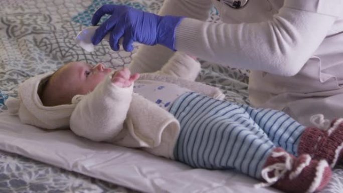 家庭护理员。新型冠状病毒肺炎大流行期间，医生在家里拜访了一名新生婴儿。儿科医生对孩子进行例行体检。监