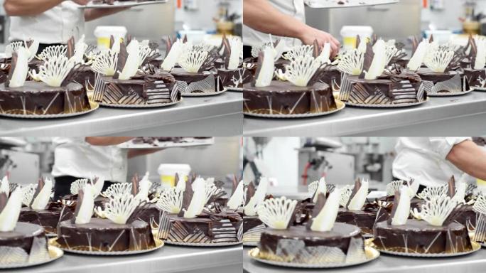 糕点师在糕点店的厨房里装饰几个蛋糕。