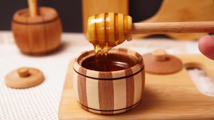 罐子上方有芳香天然有机蜂蜜的木棒。犹太新年健康假期概念。传统有用的甜味。