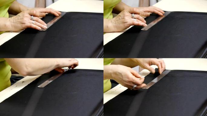 女裁缝的手在工作。裁缝师在缝制优质织物并制作一件高级时装之前，先将其切成黑色。传统观念、工业和时尚。