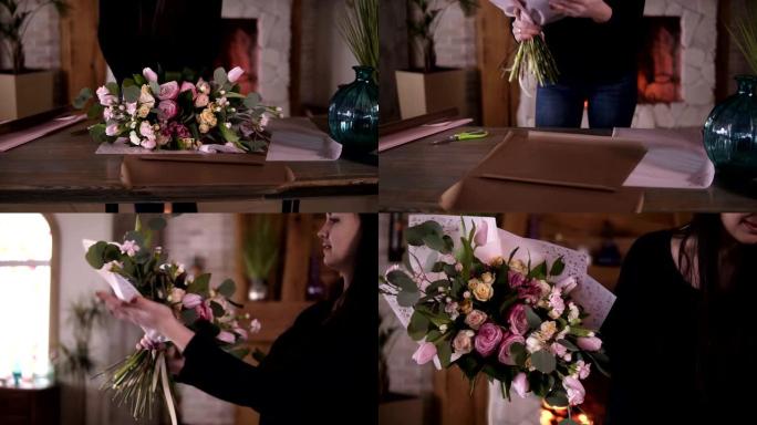 职业女性花卉艺术家，花店在家庭工作室工作室的礼品纸上包装鲜花-粉色玫瑰。花艺、手工制作和小型企业概念