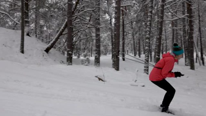 滑雪旅游-年轻夫妇在白雪皑皑的冬季森林中滑雪下山