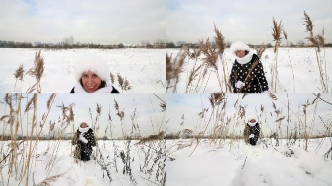 女孩走过冬天的荒原。坐在高大的干草中间。周围有很多雪。