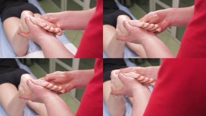 物理治疗师对患者的脚进行深层组织按摩的特写镜头。损伤康复概念