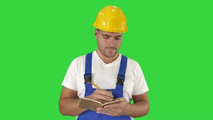 建筑工人在绿屏上写待办事项清单或清单，色度键