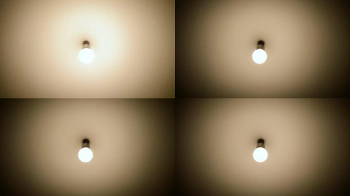 灯泡没有灯悬挂在天花板上，同时打开和关闭。一个古老而阴暗的房间的照明。