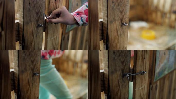 小女孩打开门闩，打开宠物动物园的木门，去兔子家。