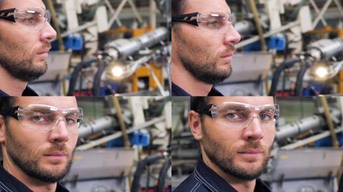 现代工具技术行业工程师工人肖像制造工厂穿着安全制服。年轻英俊的工人工夫在工业工厂近距离看相机