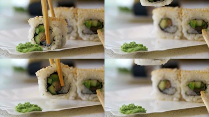 日本餐厅的筷子从盘子里拿寿司卷