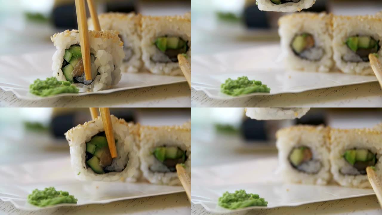 日本餐厅的筷子从盘子里拿寿司卷