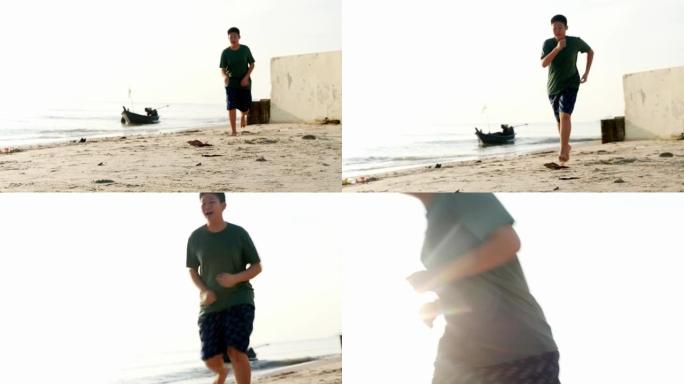 亚洲男孩早上在沙滩上慢跑，阳光明媚，生活方式概念。