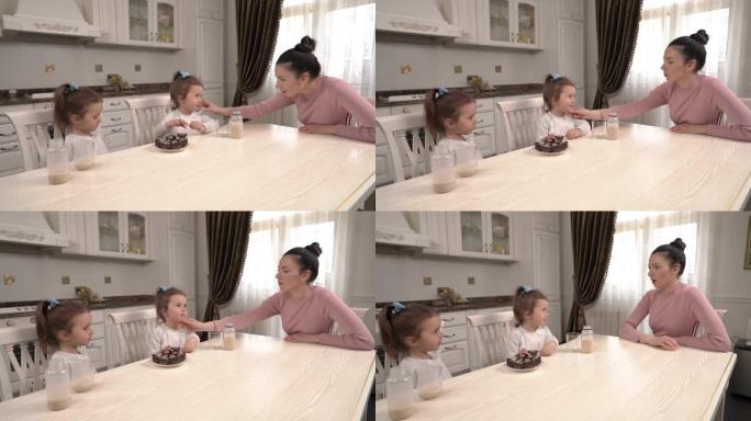 小双胞胎吃健康营养甜点并在厨房与母亲交谈的演示视频。短暂的午休时间