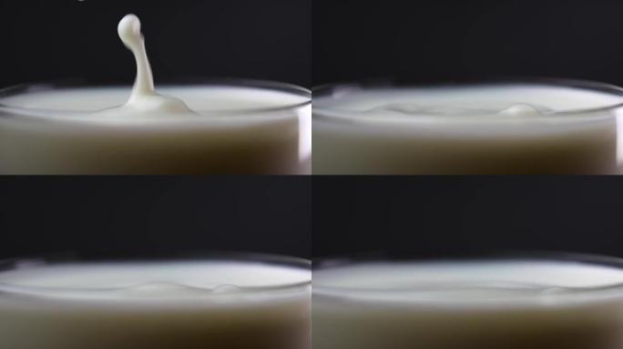 牛奶滴掉进装满的杯子里。慢动作。