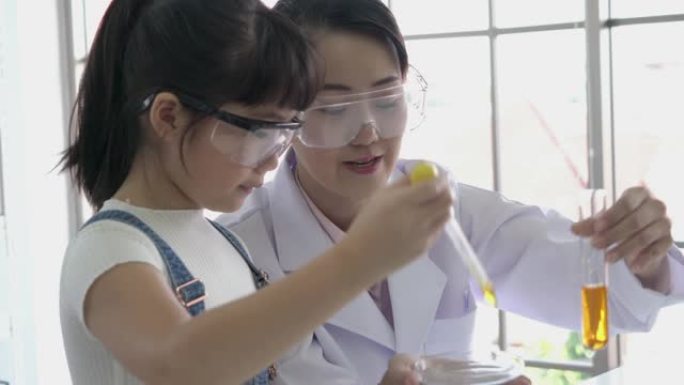 科学家的女人和小女孩正在试验化学物质化合物和吸收液体的试管。科学、测试开发和实验室行业的概念。