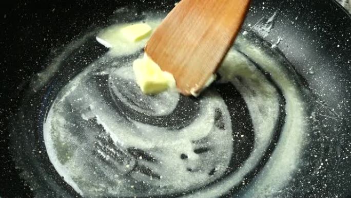 在带有不粘涂层的煎锅上涂黄油。