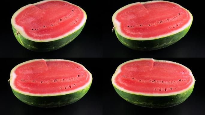 黑色背景上的一个大的成熟红西瓜的一半