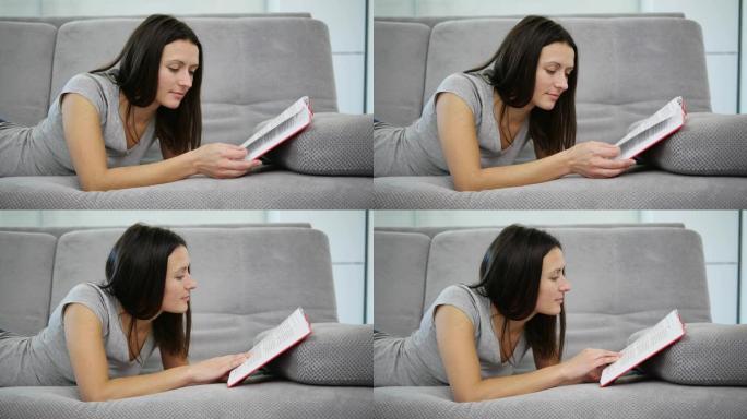 一个女人坐在沙发上读一本红皮书
