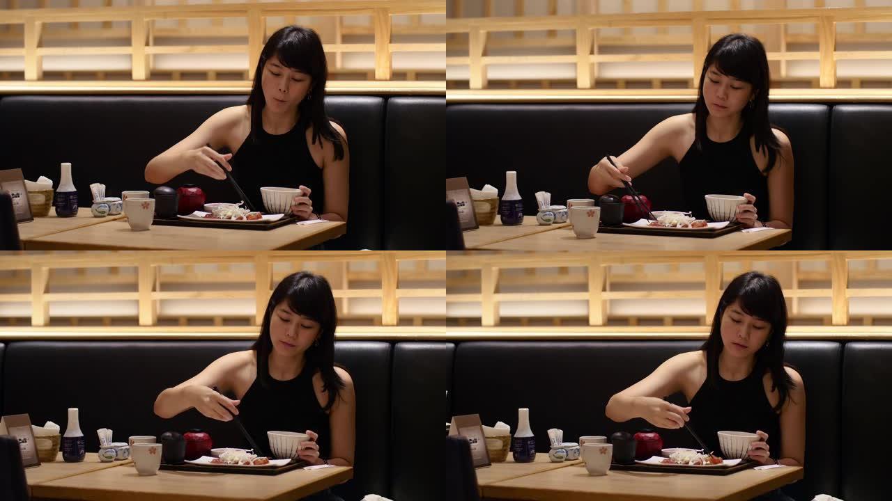 亚洲女士用筷子吃祖克马格罗新鲜金枪鱼生鱼片日本菜