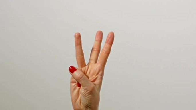 女性手与美丽的红色光泽指甲计数从1到5与手指。
