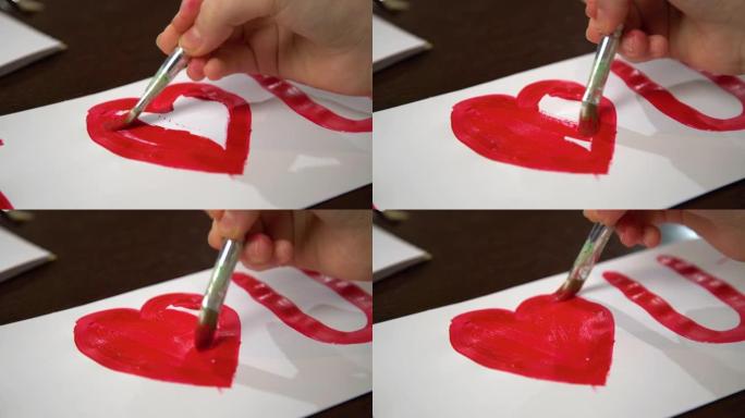 手绘我爱你的心用白纸上的红色颜料。制作情人节贺卡的特写。