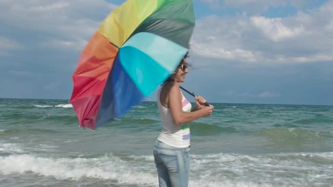 沙滩上打着彩虹伞的女人。