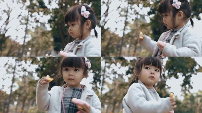 一个亚洲小女孩在公园里玩玩具相机