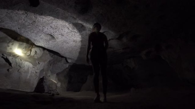 用手电筒探索洞穴的女游客
