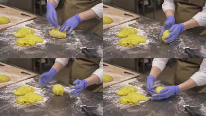 面包师揉捏散装面团的特写镜头，将其变圆并成形为所需的最终形状。