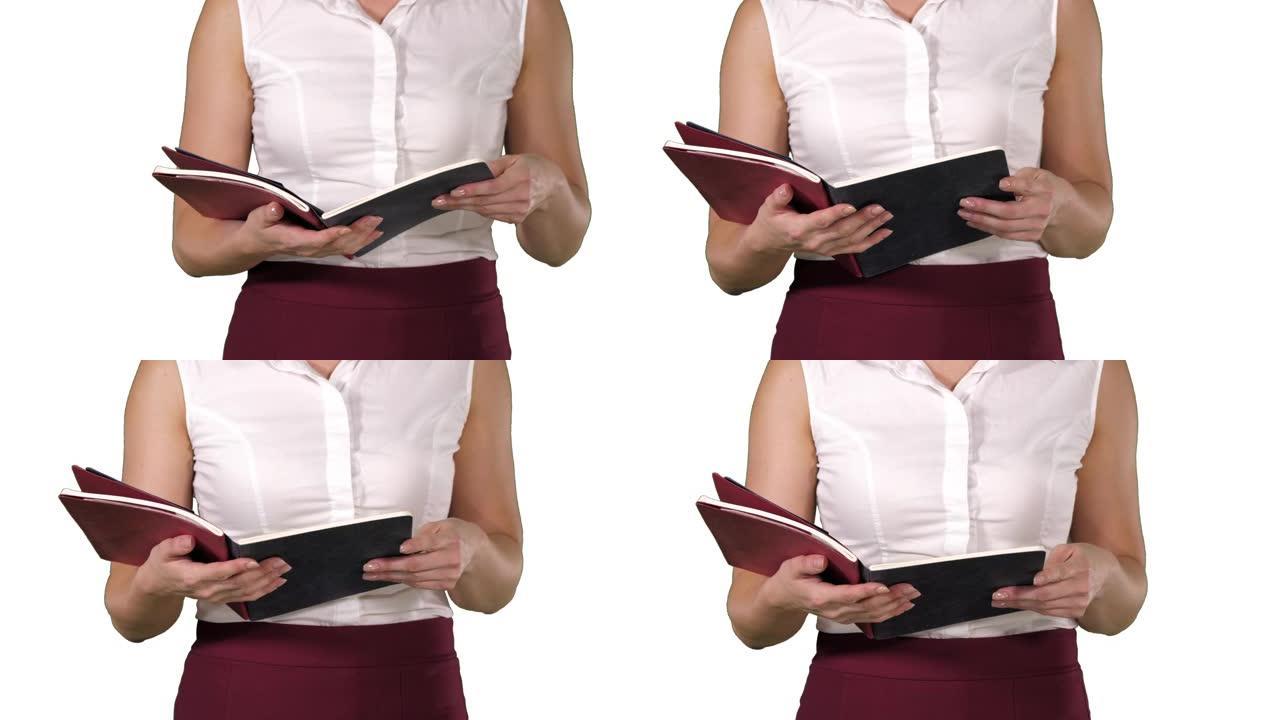 女人手握笔记本，翻页看白色背景