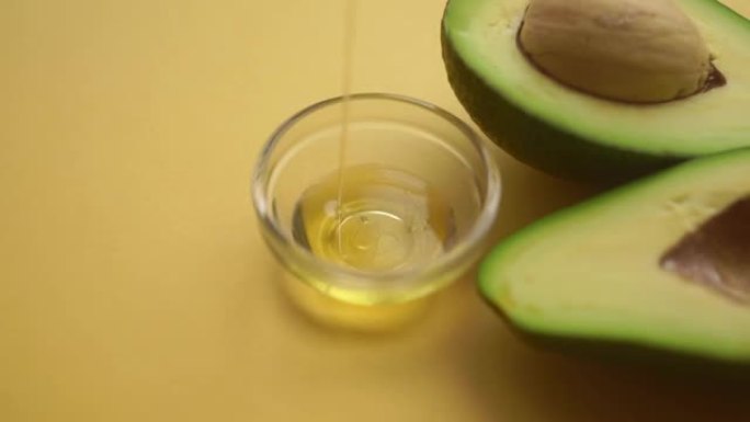 鳄梨和鳄梨油倒在水果上。食品和化妆品用鳄梨油。