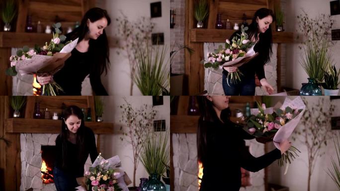 休闲花卉艺术家中的黑发女人，花店在家庭工作室车间用礼品纸包装鲜花 -- 粉色玫瑰。花艺、手工制作和小